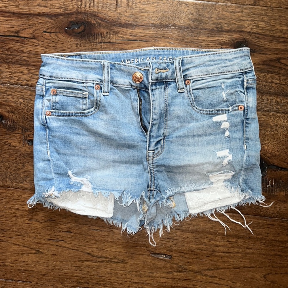 Ripped jean shorts, white patterned pockets